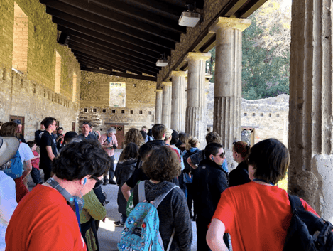 Students in pompeii listening to a guided tour