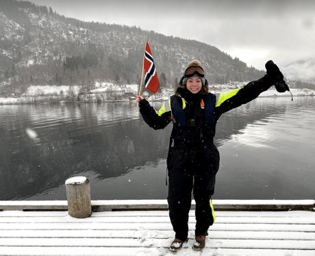 Student in Balestrand, Norway in winter with Norway flag.