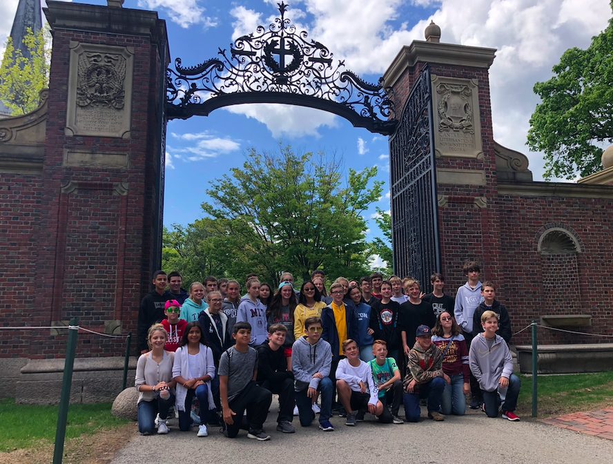Students at the Harvard University gates in a group photo.