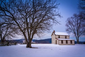 Small house and trees in a snow-covered field in Gettysburg, Pennsylvania.