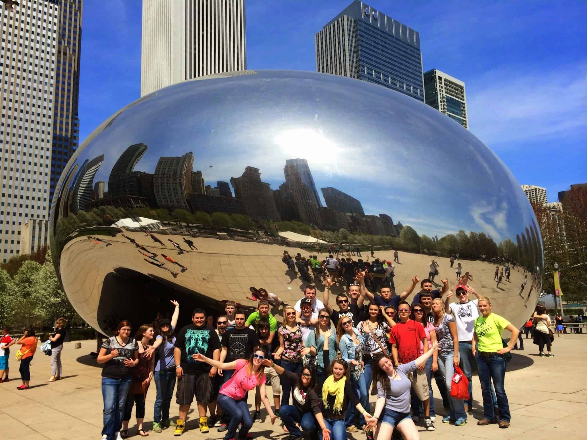 students on a school trip in front of cloud gate in chicago