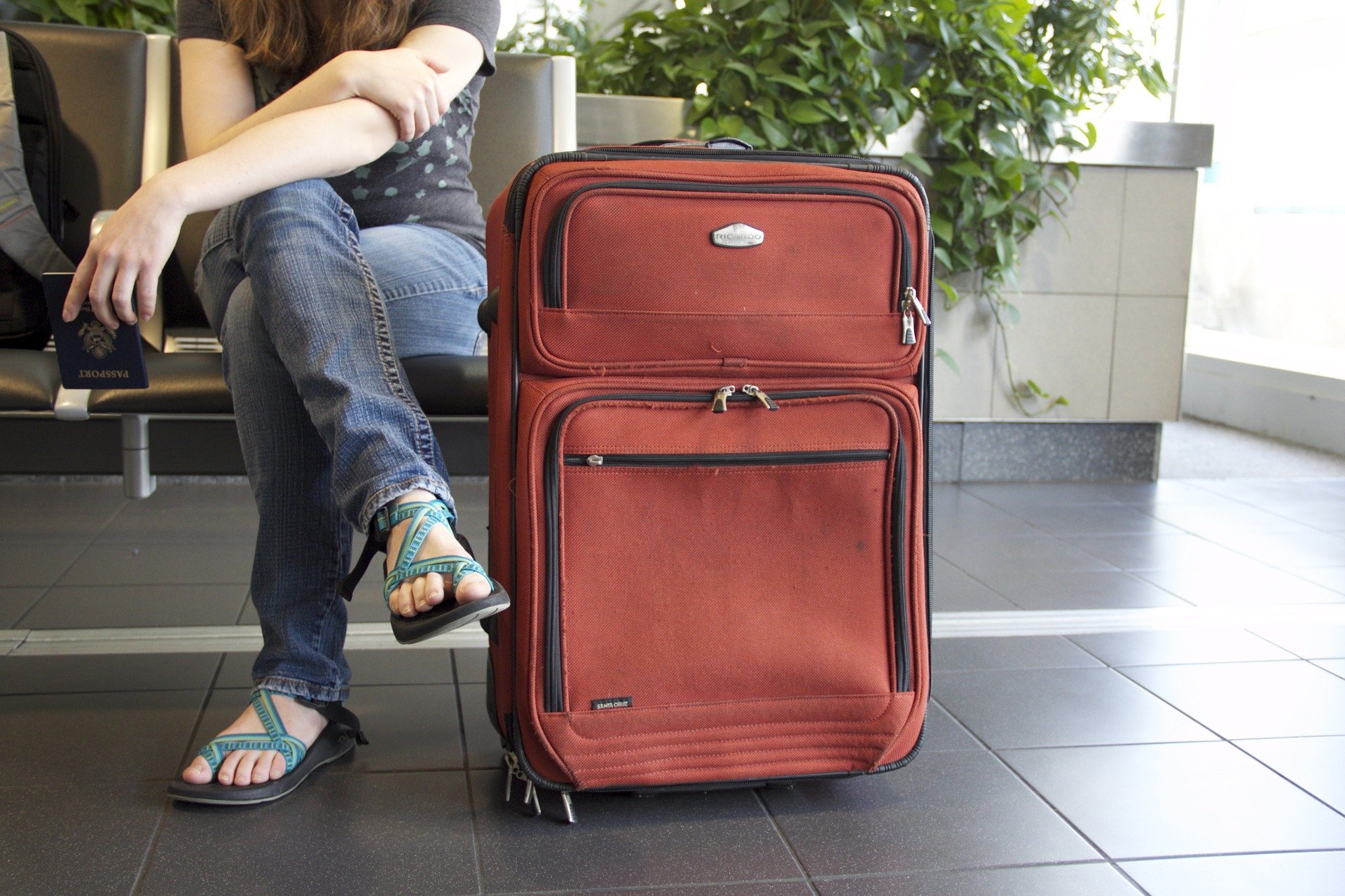 Legs of a person with a suitcase in the airport. 